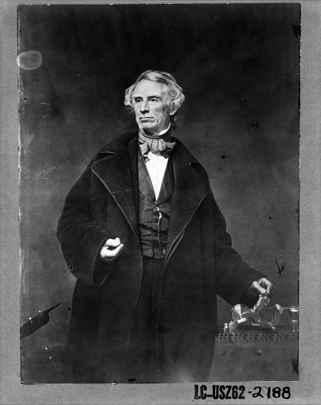Samuel F. B. Morse standing beside an early telegraph apparatus